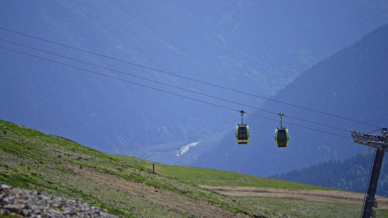 Cabine della funivia che si muovono attraverso un paesaggio montano panoramico