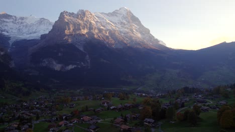 Imágenes-Aéreas-De-Drones-Empujando-Sobre-El-Pueblo-De-Grindelwald,-Vista-De-La-Puesta-De-Sol-Del-Monte-Eiger