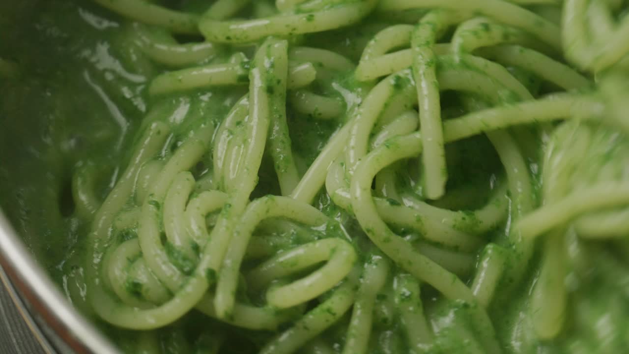 Stirring Pasta with Green Spinach Sauce during Cooking