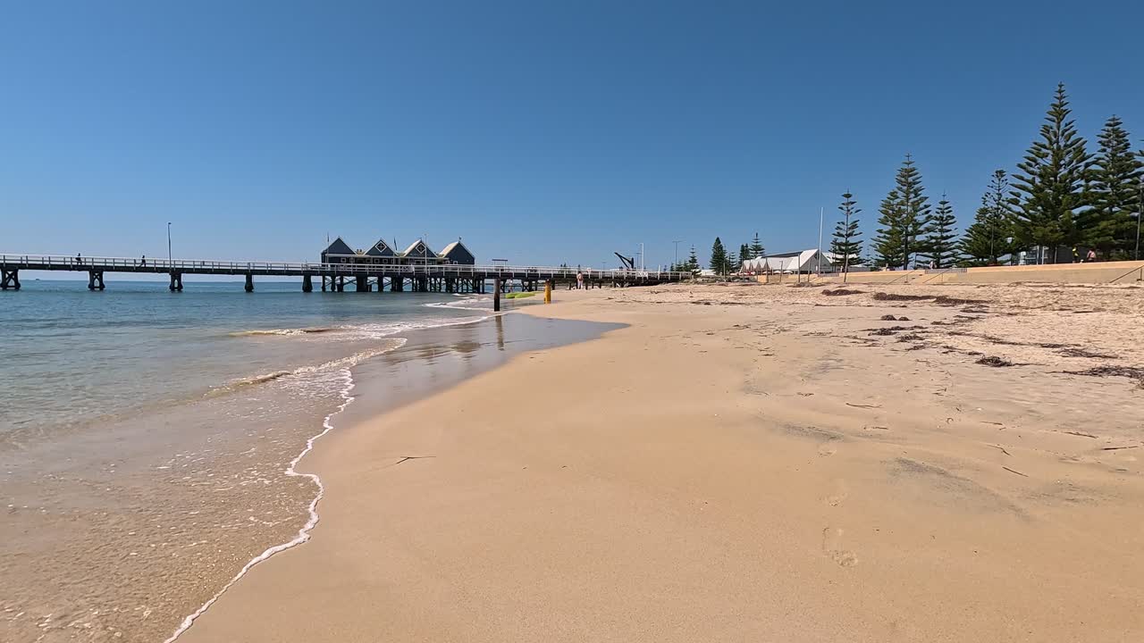 Goldener Sand und ruhiger Meerblick mit Busselton Jetty im Hintergrund