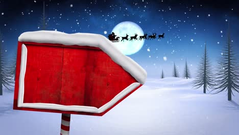 digital animation of snow falling over red wooden sign post on winter landscape and santa