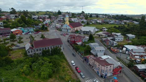 Flyover-establishing-the-centenary-street-and-the-patrimonial-church-of-Chonchi-in-Chiloe,-Chile