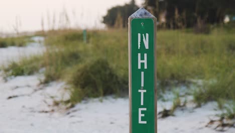 white avenue sign during sunset with sand and grass in background on anna maria island, fl