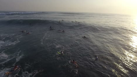 aerial view of surfers on surfboards in rough sea