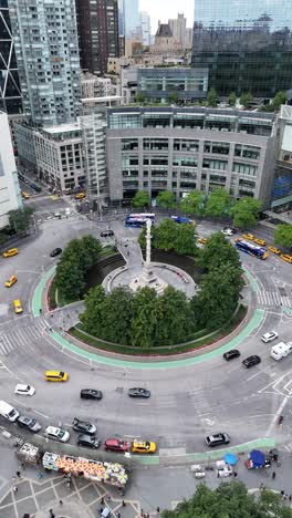 vertical drone shot pushing into columbus circle in nyc, capturing the busy traffic and surrounding skyscrapers