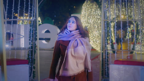 la chica camina y disfruta de las luces de navidad en cámara lenta.