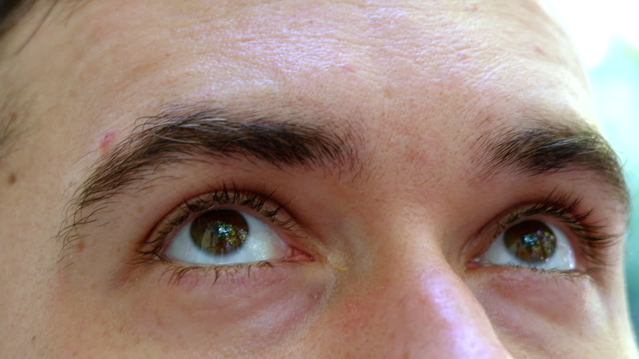 Close up of a man with brown eyes on a blurry background