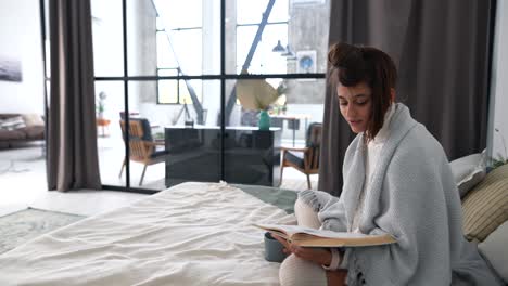 woman reading in cozy bedroom