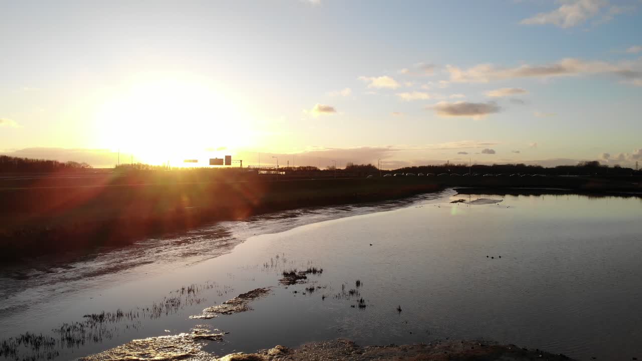 Golden Sunlight Over Downtown By The Peaceful River During Sunset. - Aerial Pullback Shot
