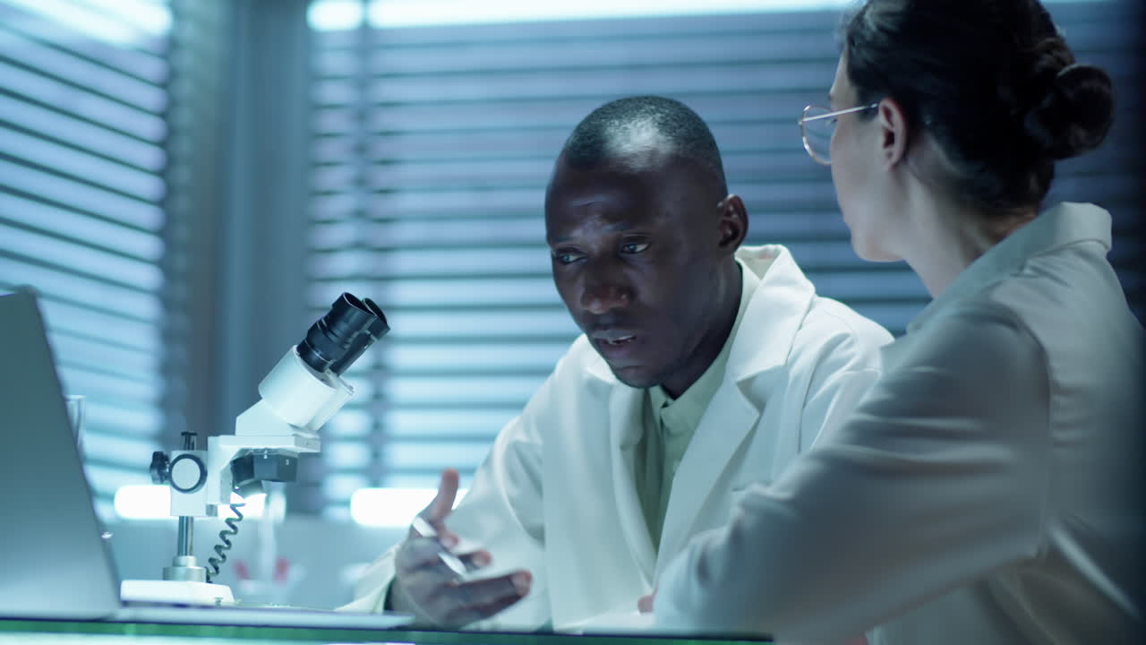 Multiethnic Lab Scientists Discussing Project on Laptop