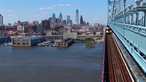 a rapid transit train drives across ben franklin bridge away from philadelphia pennsylvania  1