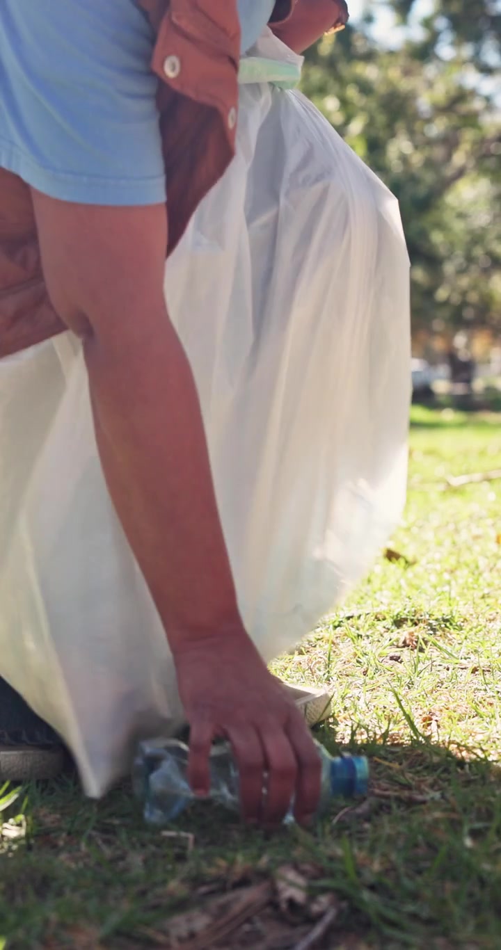 Volunteer Picking Up Plastic Bottle Litter in a Park