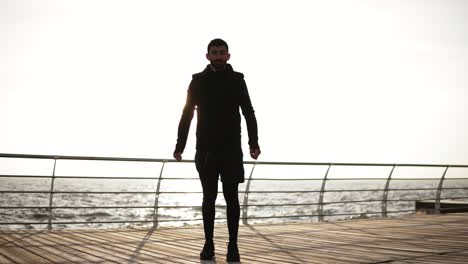 Joven-Deportista-Haciendo-Ejercicio-En-El-Muelle-Cerca-De-La-Playa.-Hermosa-Mañana-Soleada-En-La-Costa.-Metraje-Al-Aire-Libre.