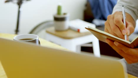 man writing on a diary in living room at home 4k