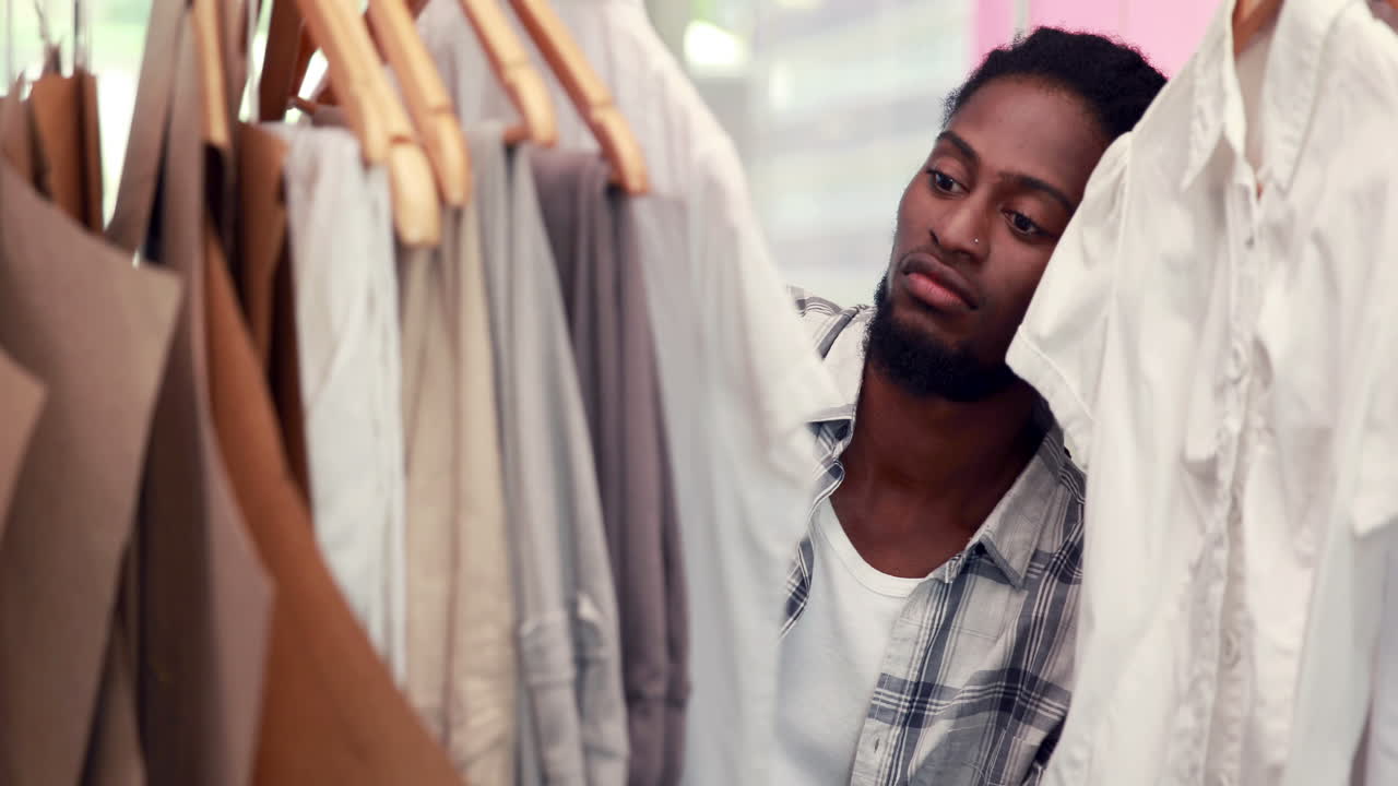 Male fashion designer looking at rack of clothes