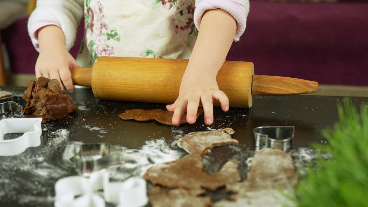 Close-up shot of making gingerbread cookies for Christmas, with child’s hands in the kitchen at home