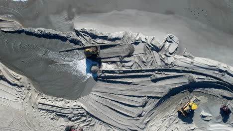 drone shot of beach nourishment, or adding sand or sediment to beaches to combat erosion, with water coming out of pipe