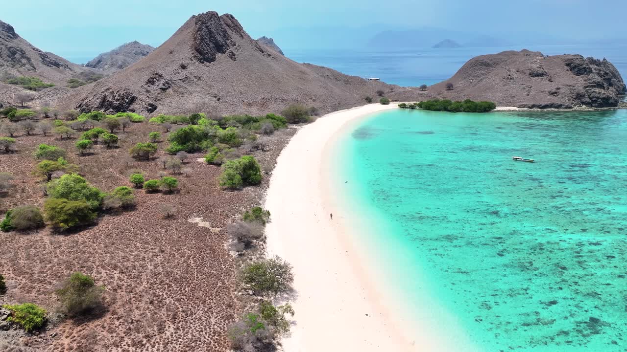 Beautiful nature of Komodo Island with clear waters. Man on Pink Beach. Travel destination.