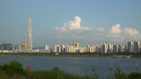 seoul city view with people windsurfing under sails and lotter world tower on cloudy sunny day