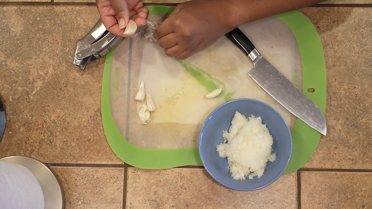 Peeling organic garlic cloves to use in a homemade soup recipe - overhead view WILD RICE SERIES