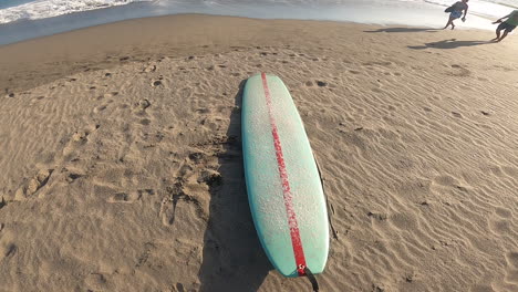 Surfista-Turístico-De-Pie-Con-Una-Tabla-De-Surf-En-La-Playa-De-Arena-En-Canggu,-Bali,-Indonesia