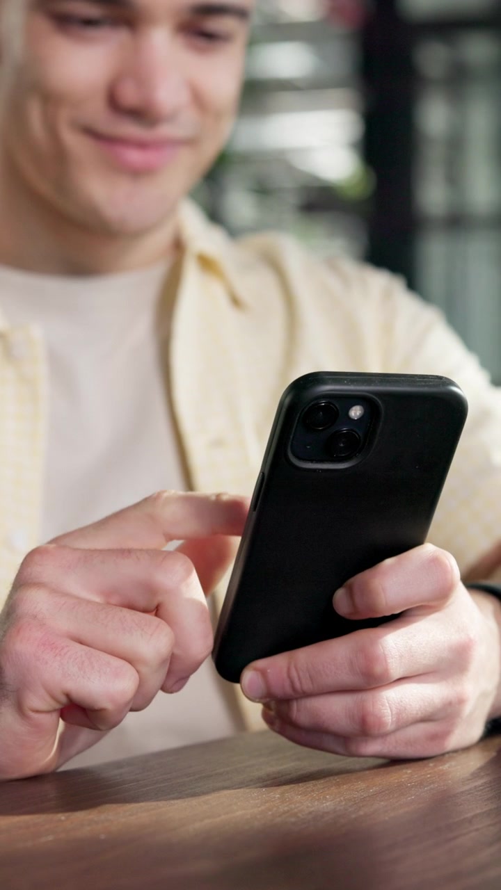 Giovane che utilizza smartphone nel caffè