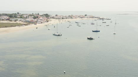 catamaran and sailboats floating near the armona island in algarve, portugal