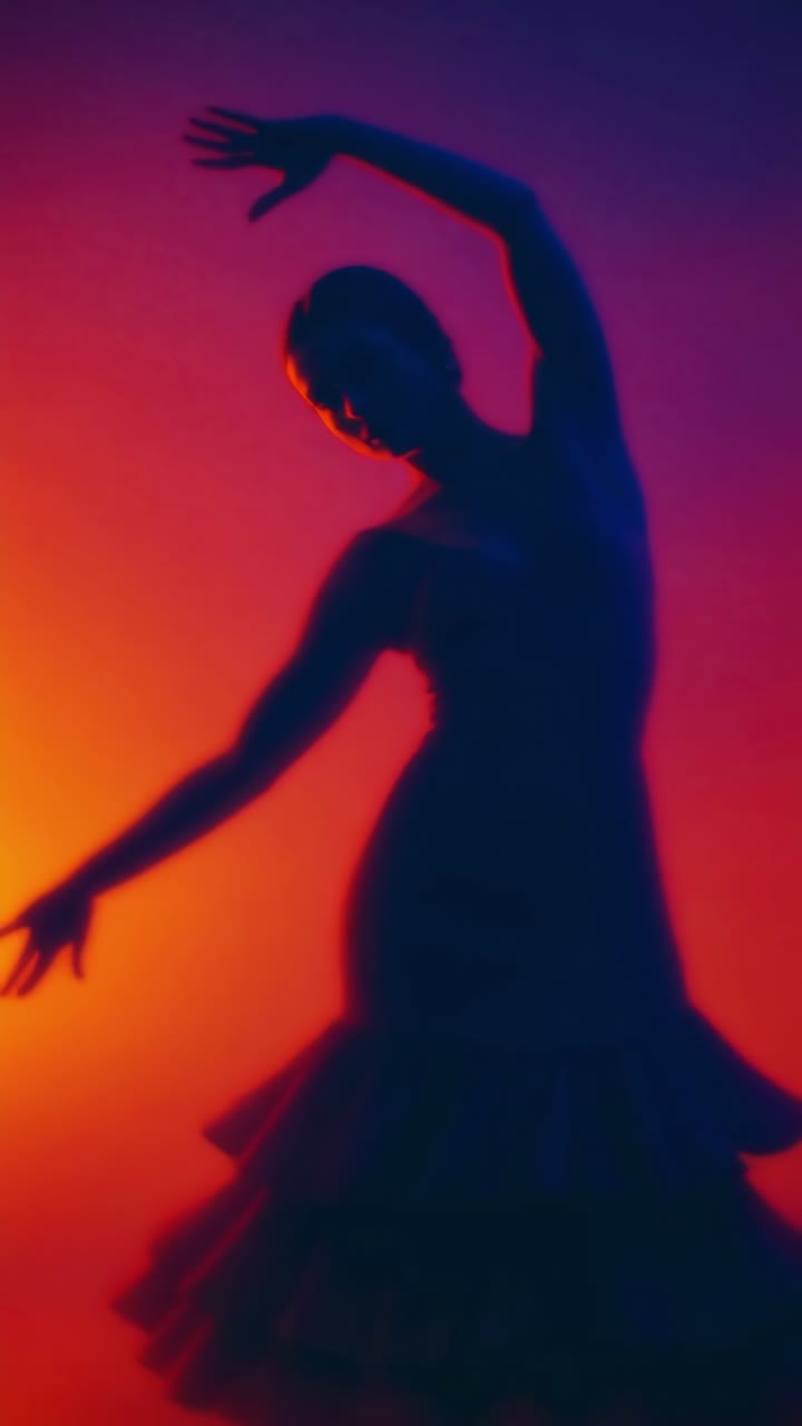 Silhouetted dancer in motion against a vibrant gradient background