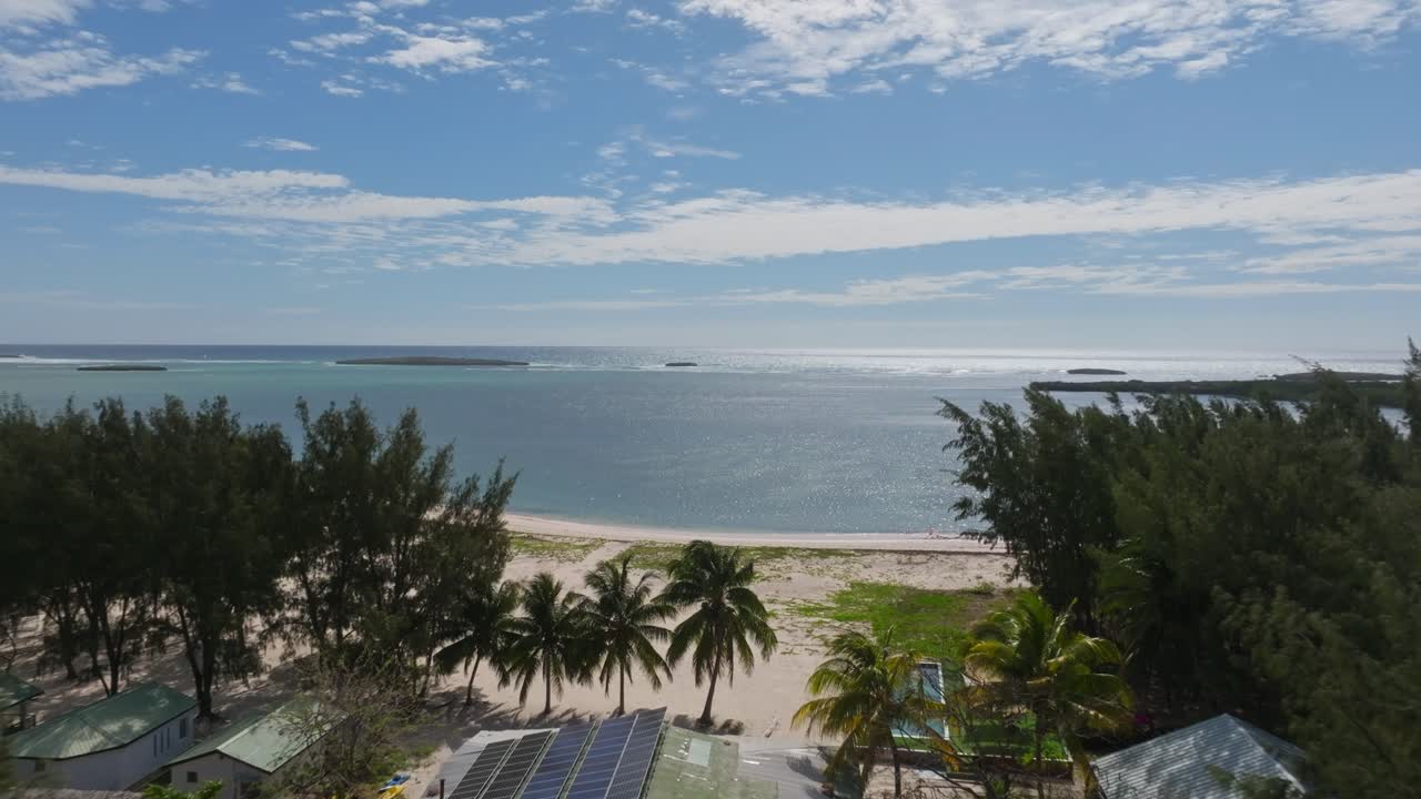 Smooth dolly shot from island to sea, capturing Sakalava Bay’s pristine beach and turquoise waters