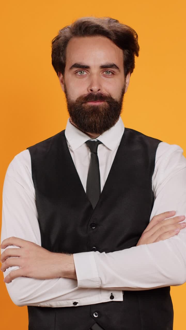 Video verticale Maggiordomo elegante su sfondo giallo in studio