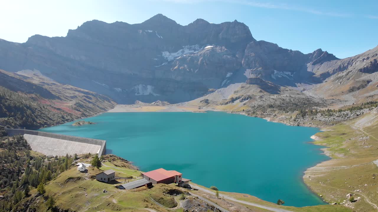 sobrevuelo aéreo sobre las orillas y el agua del lago de salenfe en valais, suiza en un soleado día de otoño en los alpes suizos con una vista de picos alpinos, acantilados y presa hidroeléctrica