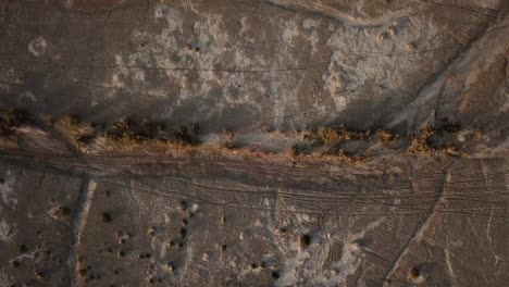 Desert-Birds-eye-drone-shot-aerial-salt-lake-in-mountain-foothill-abandoned-land-poverty-agriculture-local-people-life-countryside-mineral-water-drought-climate-dry-crisis-in-hot-summer-season-in-Iran