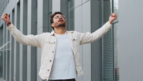 indian man taking a deep breath of fresh air relaxing taking a break resting meditating outdoor