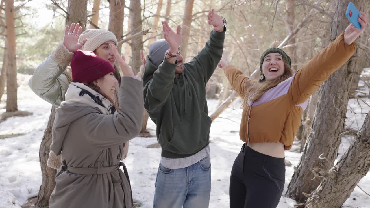 Group of friends taking a selfie in a snowy forest