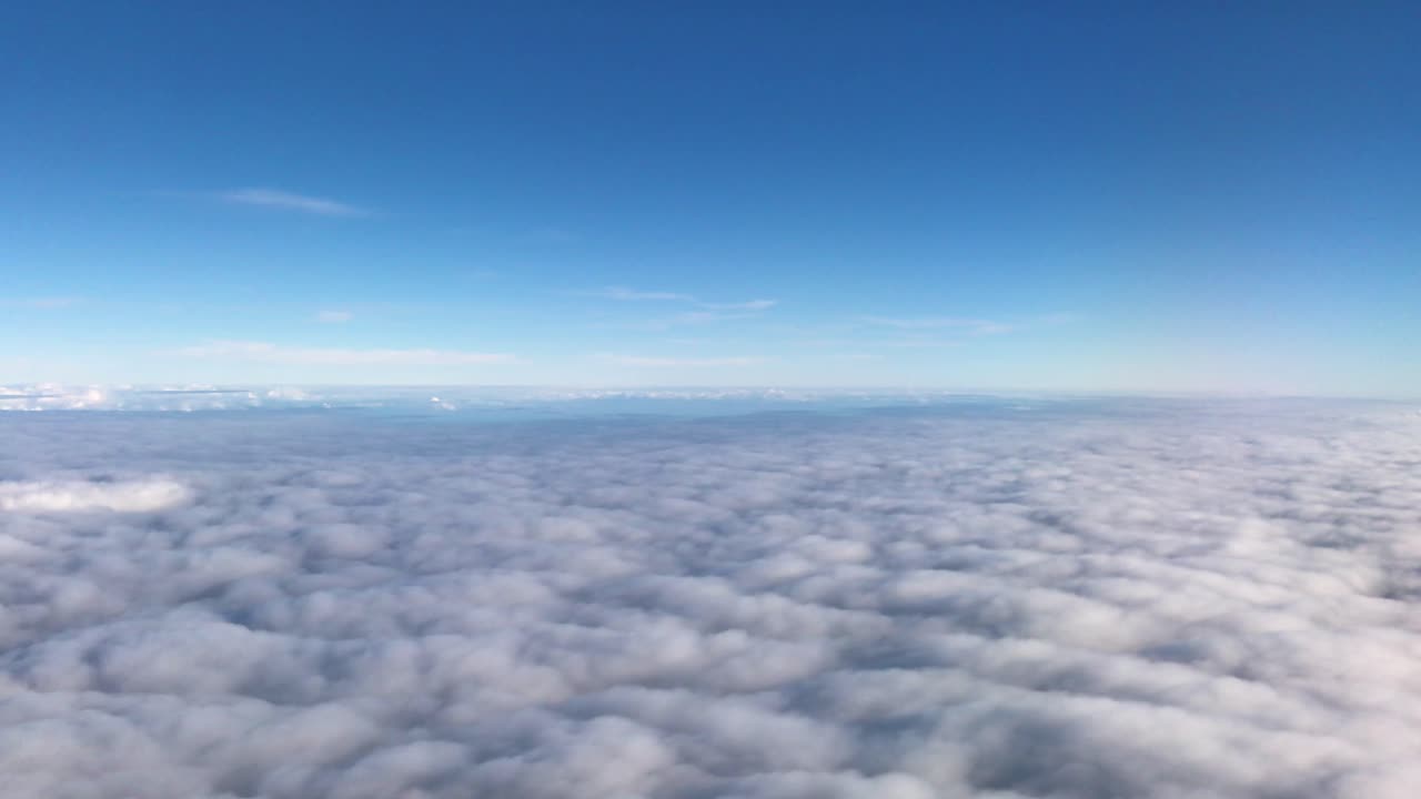 vista desde la ventana de un avión, nubes esponjosas brillantes y estratosfera azul profundo
