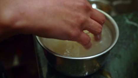 Limpieza-Manual-De-Granos-De-Arroz-En-Una-Olla-Pequeña-Con-Agua-Antes-De-Cocinar