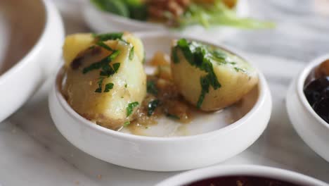 close up of a plate of boiled potatoes with parsley