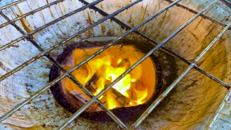 burning charcoal in a grill at market