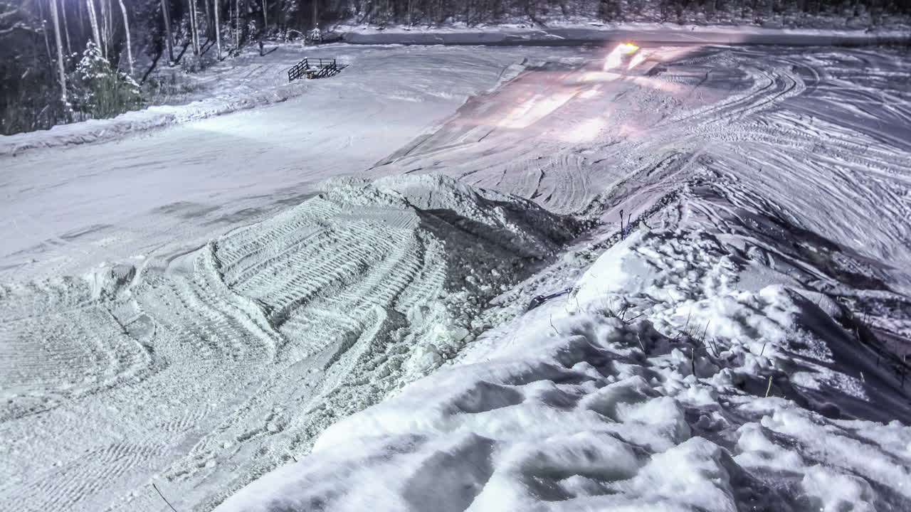 Lumen muotoilua yöaikaan laskettelu- tai lumilautahyppyriä varten – nouseva, liukuva time lapse.