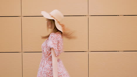 woman walking past a beige wall