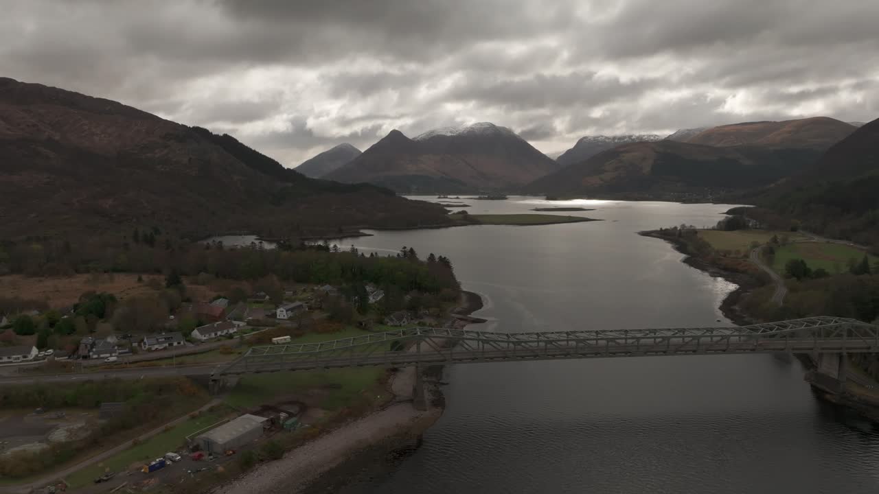 Aerial dolly shot along the Ballachulish bridge with snowy munros in the background