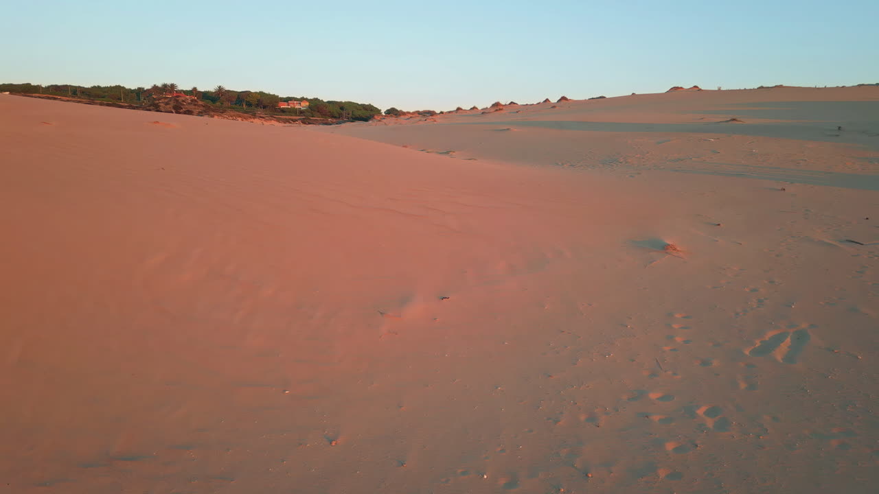 Drone flying sunset dunes painting in warm orange tones. Tranquil landscape