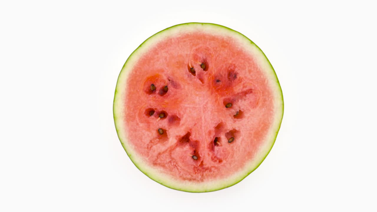 vista superior desde arriba de una rebanada de sandía madura cortada a la mitad. sección transversal. girando en la mesa giratoria aislada en el fondo blanco. primer plano.