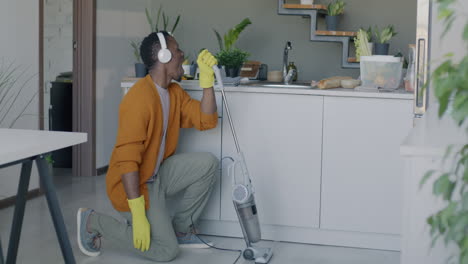 man cleaning kitchen while dancing and listening to music