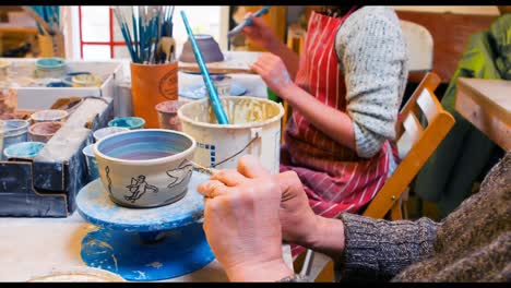 Artists-drawing-on-earthenware-bowl