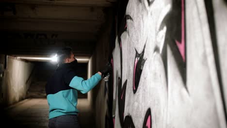 graffiti artist painting on the wall in subway