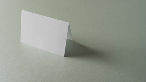 close up of two blank white business cards on yellow and grey background, copy space, slow motion