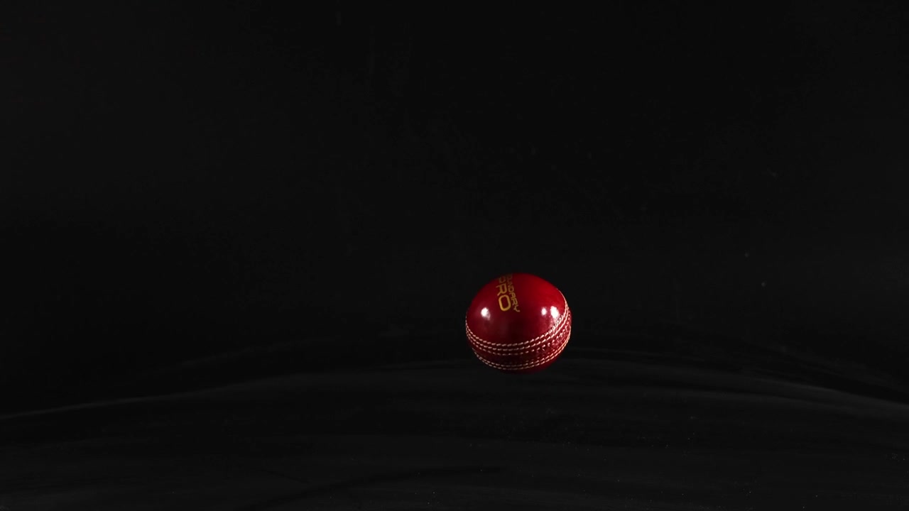 Hand dropping a cricket ball onto surface