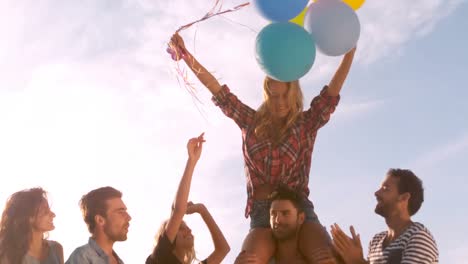 woman siting on mans shoulders holding air balloons