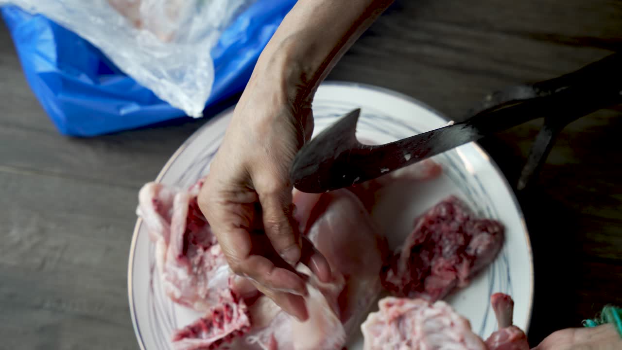 un tradizionale tagliatore di verdure, noto come "aruvamanai", è impiegato per tagliare la carne di pollo cruda